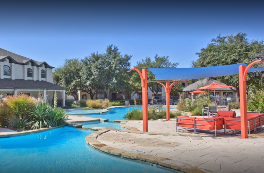 a swimming pool with a pergola and lounge chairs in front of a house