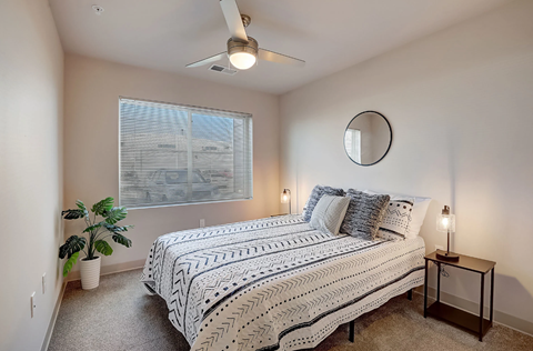 a bedroom with a bed and a ceiling fan