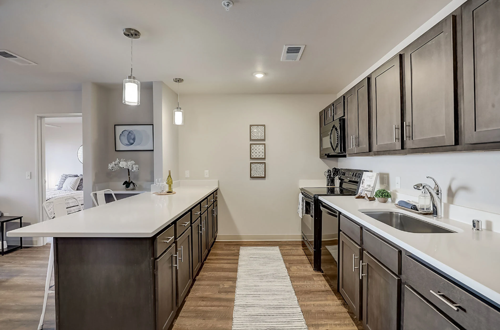 a large kitchen with stainless steel appliances and white counter tops
