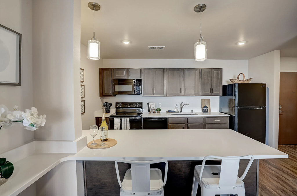 a kitchen with a white island and a black refrigerator