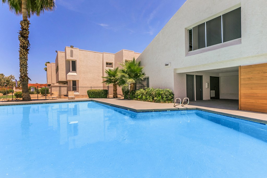 a large swimming pool with a white building in the background