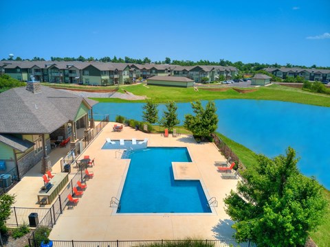 an aerial view of a resort style swimming pool with umbrellas
