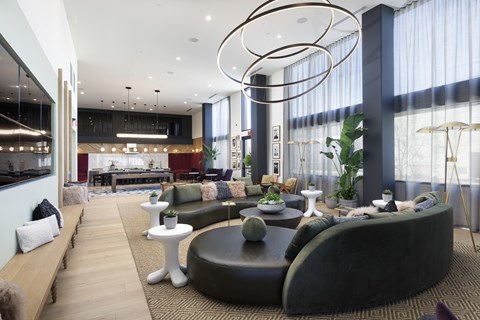 A modern living room with a large circular sofa and a long wooden bench.