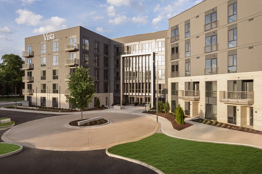 A Vista apartment complex with a circular driveway in front.