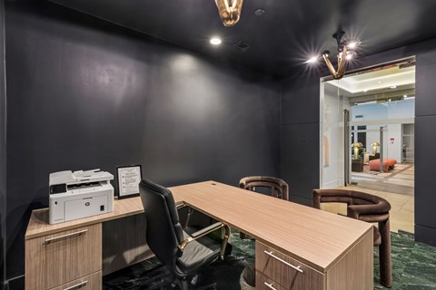 A conference room with a large table, chairs, and a printer on a desk.