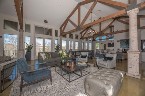 a living room with couches and chairs and exposed beams