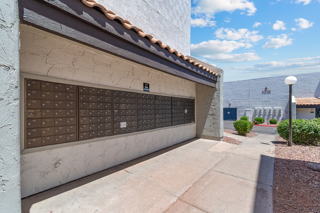 a garage with a white wall and tile roof with a blue sky in the background