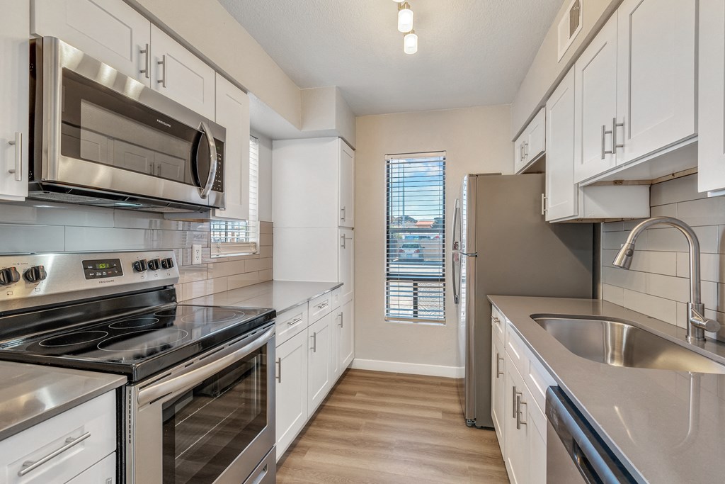 a kitchen with white cabinets and stainless steel appliances