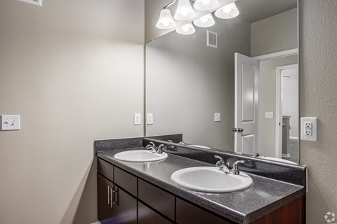 an empty bathroom with two sinks and a large mirror