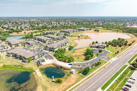 an aerial view of a community with a highway and a lake