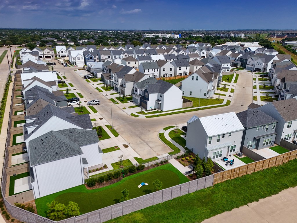 A bird's eye view of a residential neighborhood with houses and green lawns.