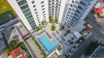an aerial view of a large apartment building with a pool in the middle