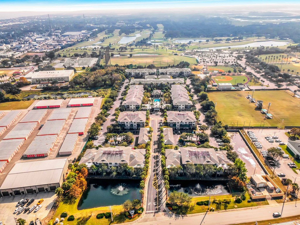 an aerial view of a city with buildings and a pond