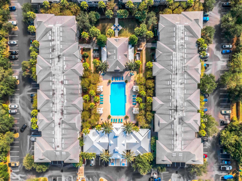 a birds eye view of a hotel with a pool and palm trees