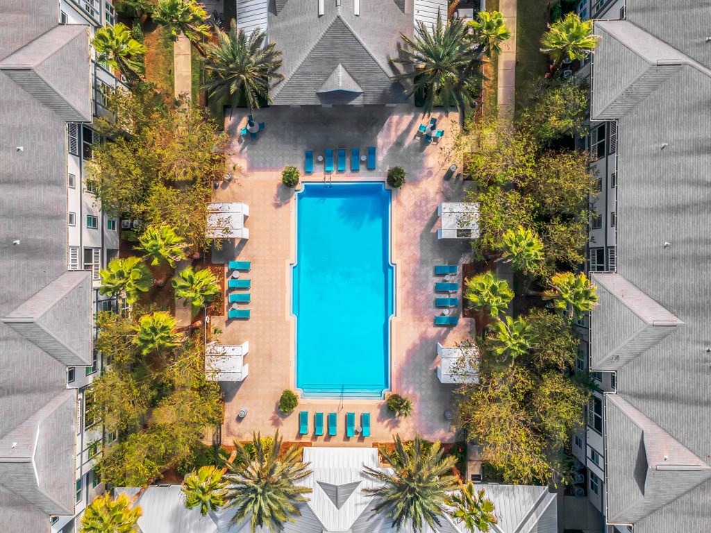 a swimming pool in the middle of a building surrounded by palm trees