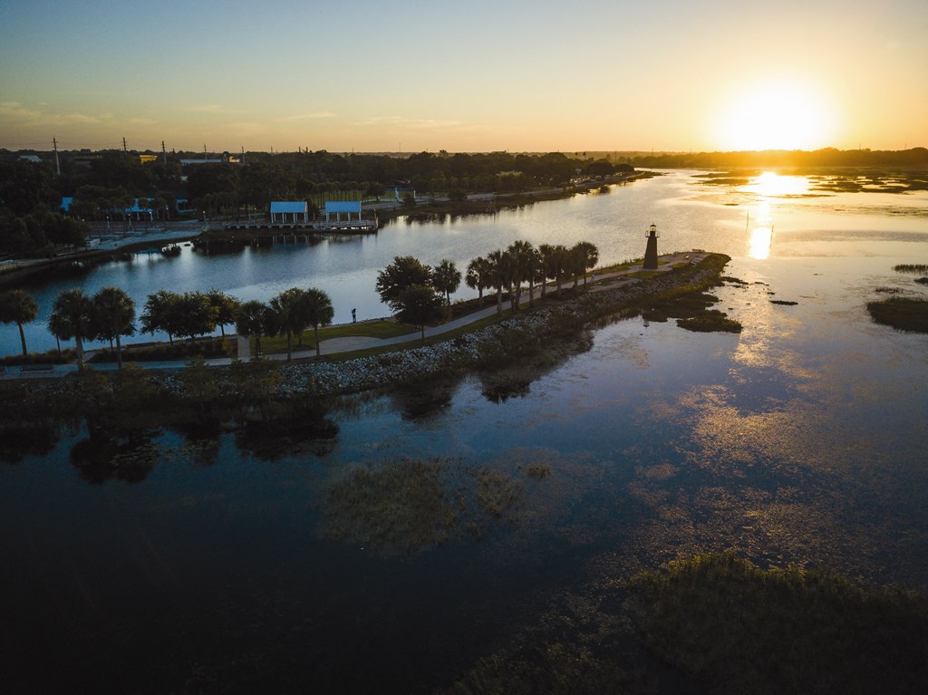 an aerial view of a lake with a sunset in the background