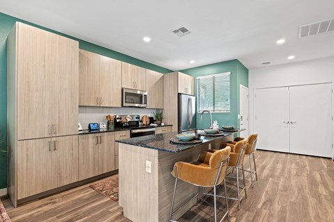 a kitchen with a large island and a bar with chairs