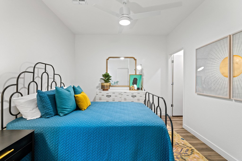 a bedroom with a bed with blue sheets and pillows