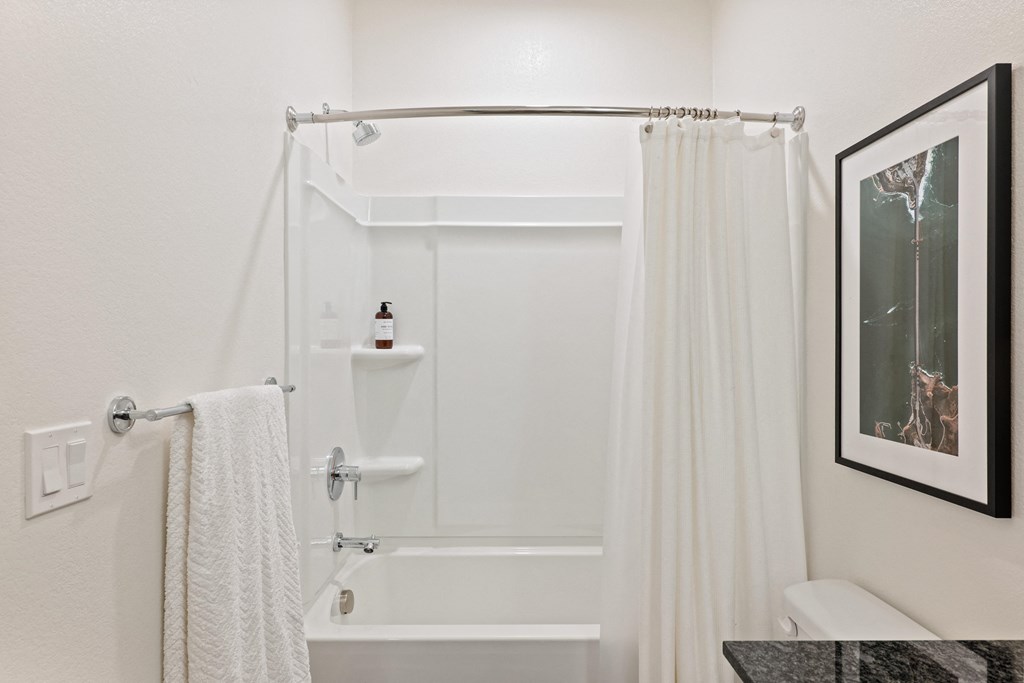 a bathroom with a shower and a sink and a shower curtain