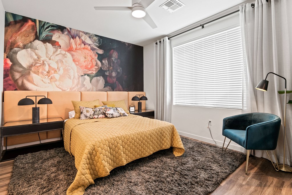a bedroom with a bed and a large painting of flowers