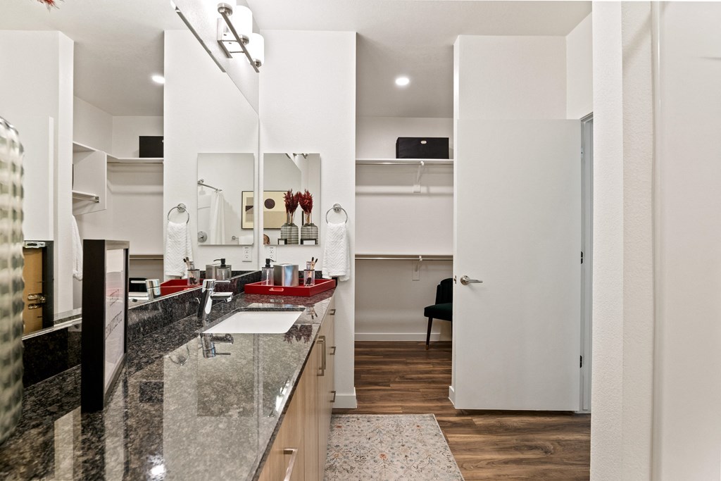 a kitchen with granite countertops and a sink and a door to a living room
