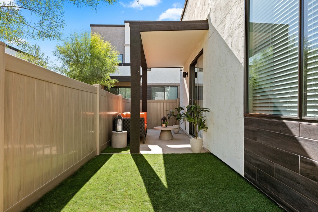 a courtyard with grass and a toilet in a house