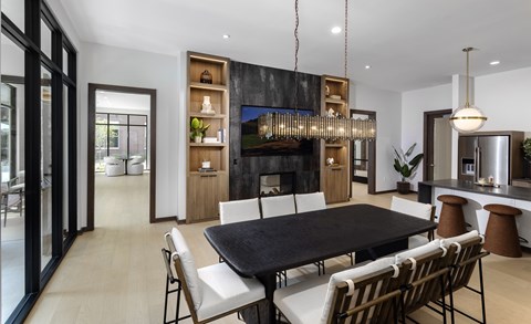 A modern dining room with a black table and chairs.