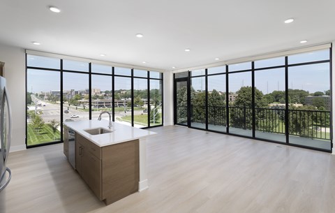 A modern kitchen with a sink and a view of the city.