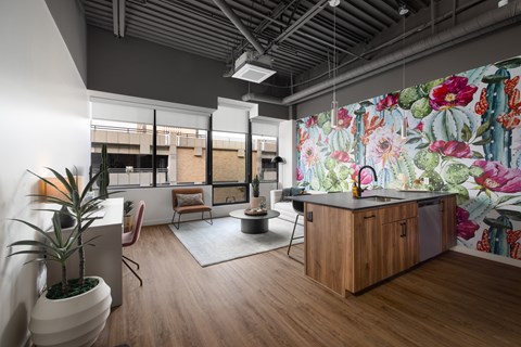 A modern kitchen with a wooden counter and a large floral mural on the wall.