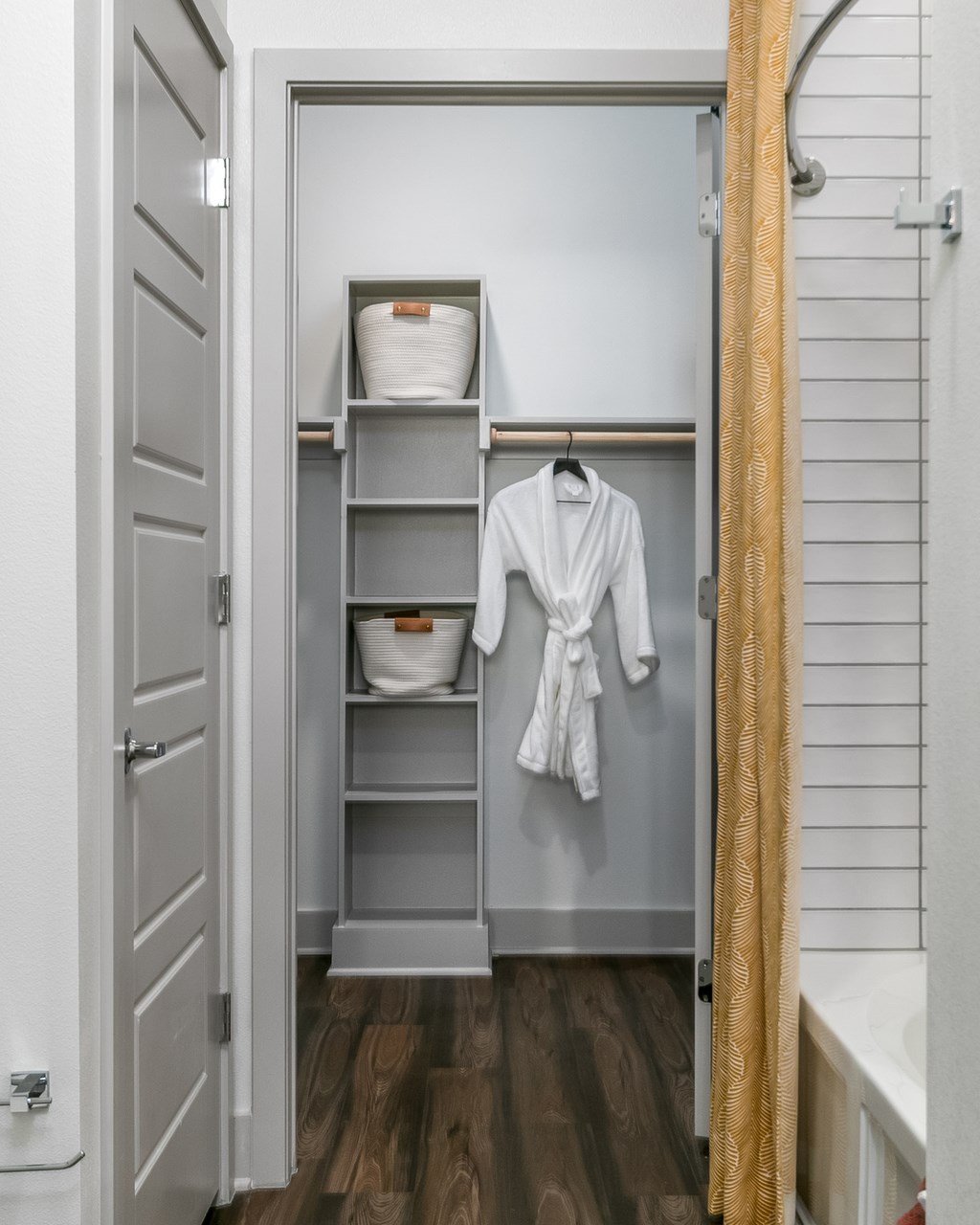 A white bathroom with a towel hanging on a rack.