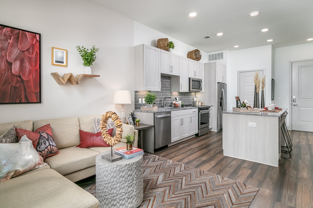 A modern kitchen with a dining table and a couch with pillows.