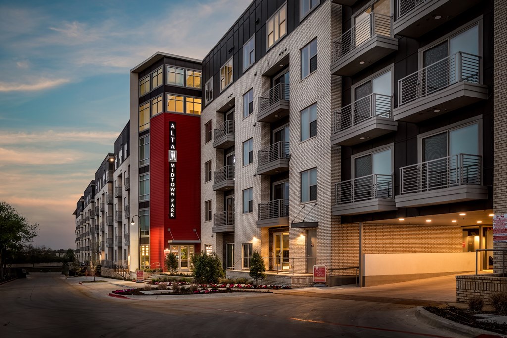 A large apartment building with a red and white sign on the front.