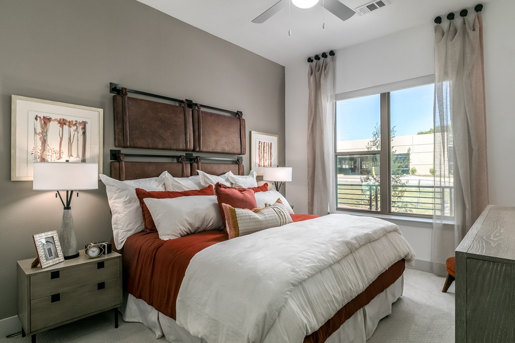 A bedroom with a large bed and a window overlooking a building.