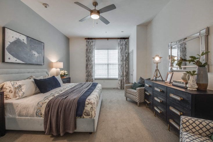 a bedroom with a bed and a ceiling fan