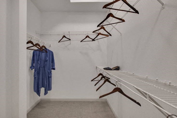a closet with some clothes and some hangers on the wall