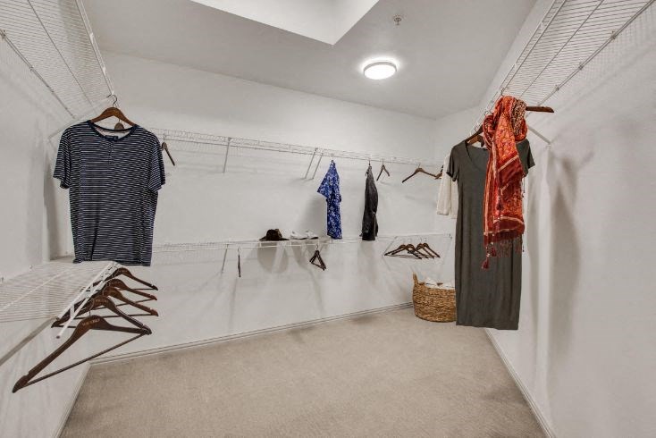 a room with clothes hanging on the wall and a rack of clothes on the floor