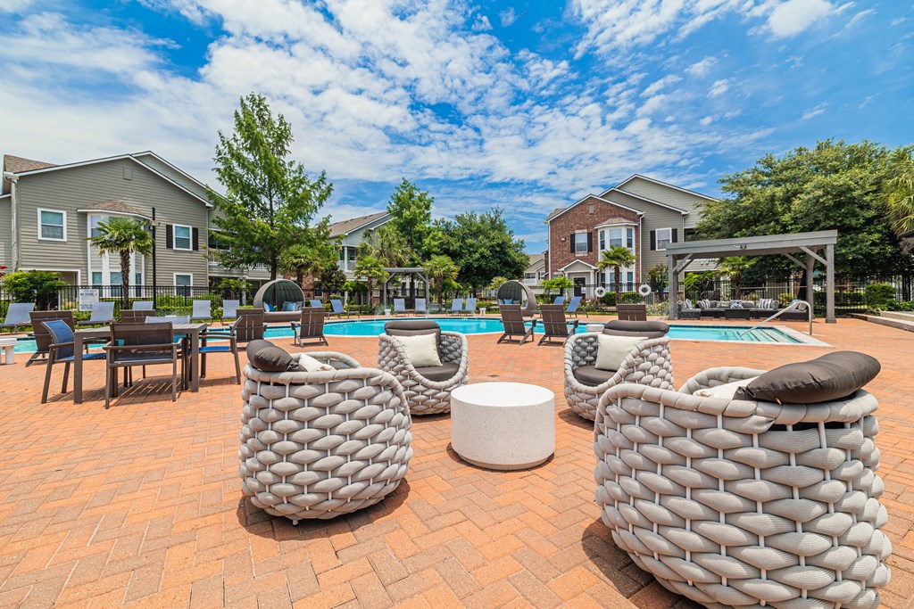 our apartments have an outdoor patio with chairs and a pool