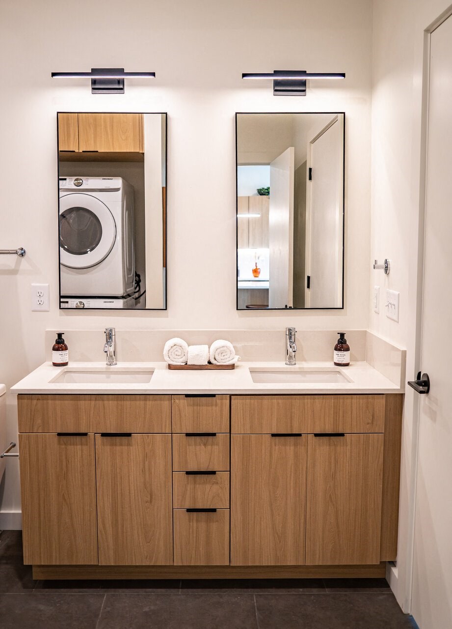 a bathroom with a sink and two mirrors