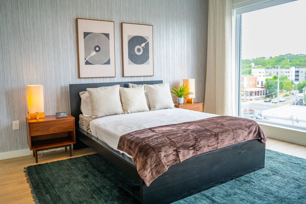 a spacious bedroom with the a large window view of Nashville