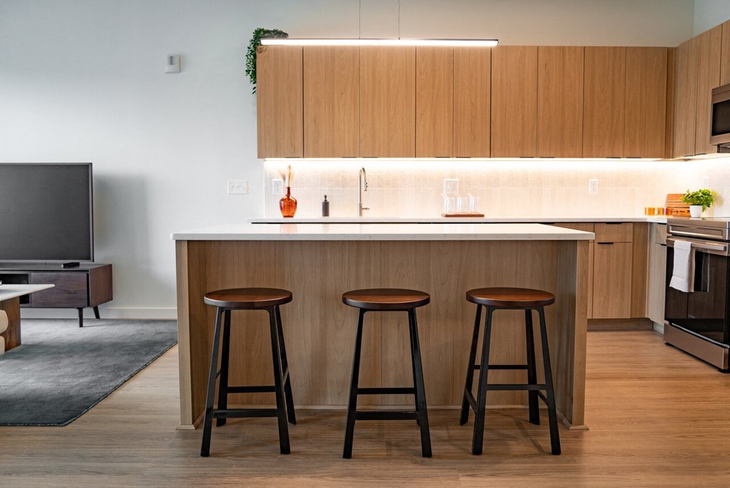 a kitchen with a counter and three stools