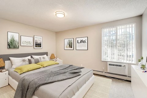 A bedroom with a bed, a window with blinds, and pictures on the wall.