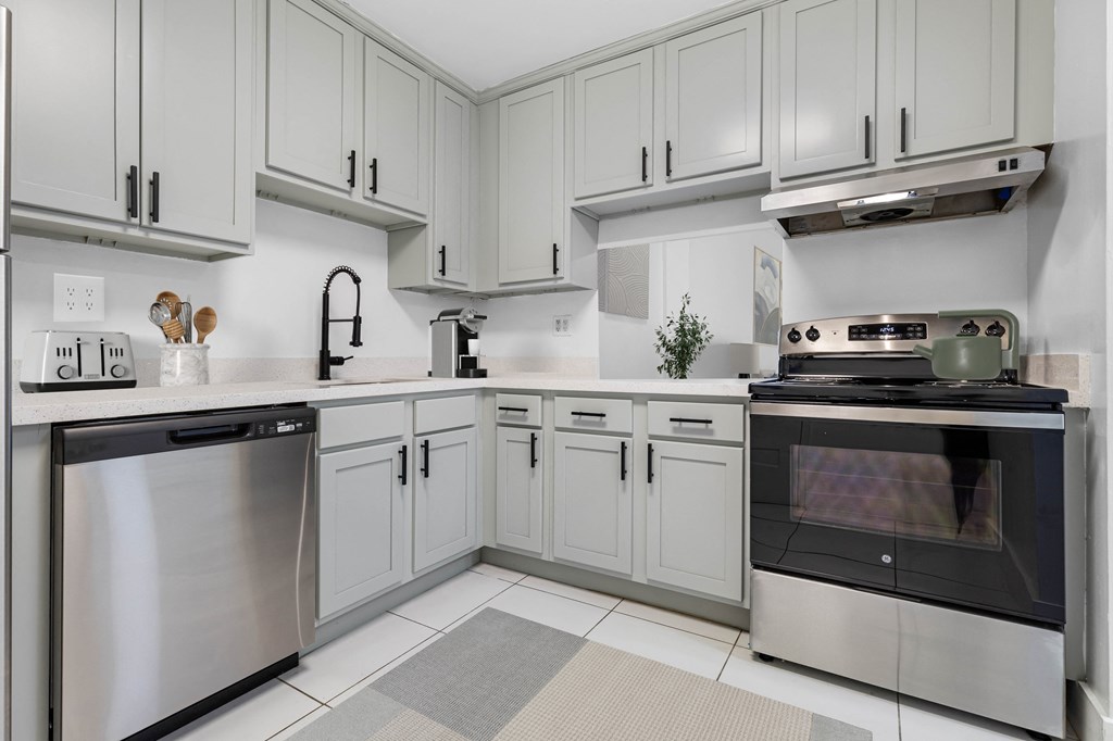 A modern kitchen with stainless steel appliances and white cabinets.