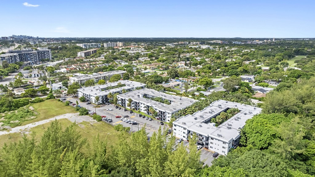 A bird's eye view of a residential area with multiple buildings and greenery.