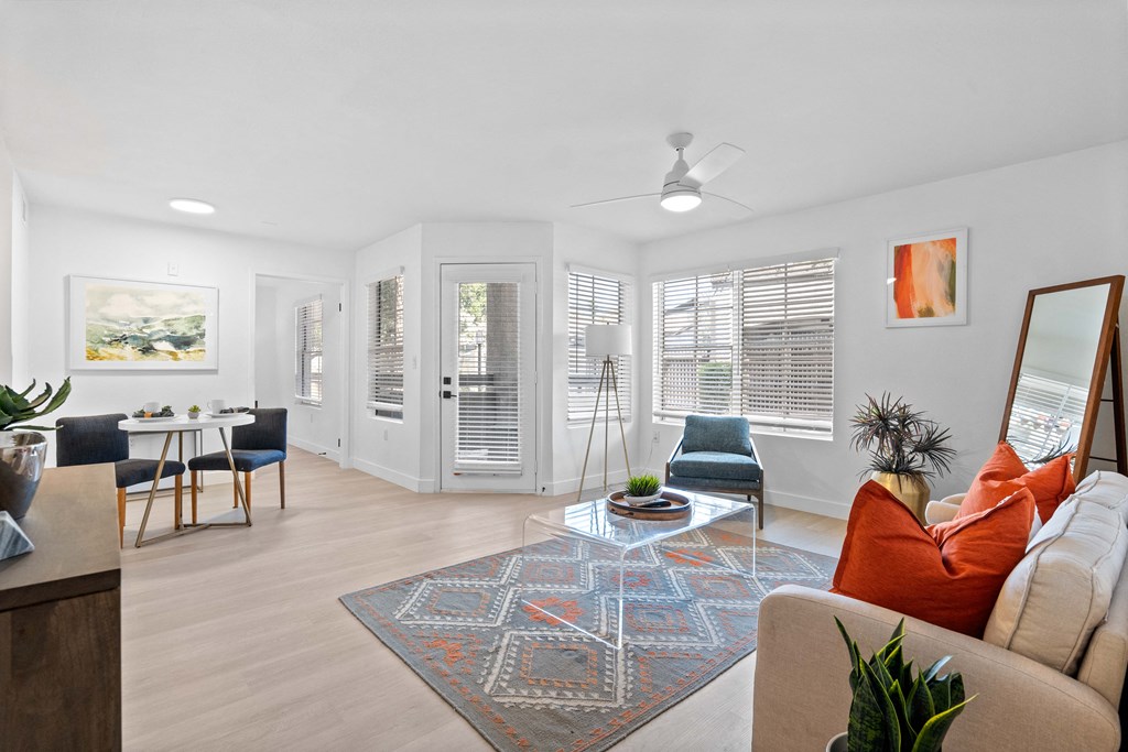 a living room with a couch and chairs and a dining room table