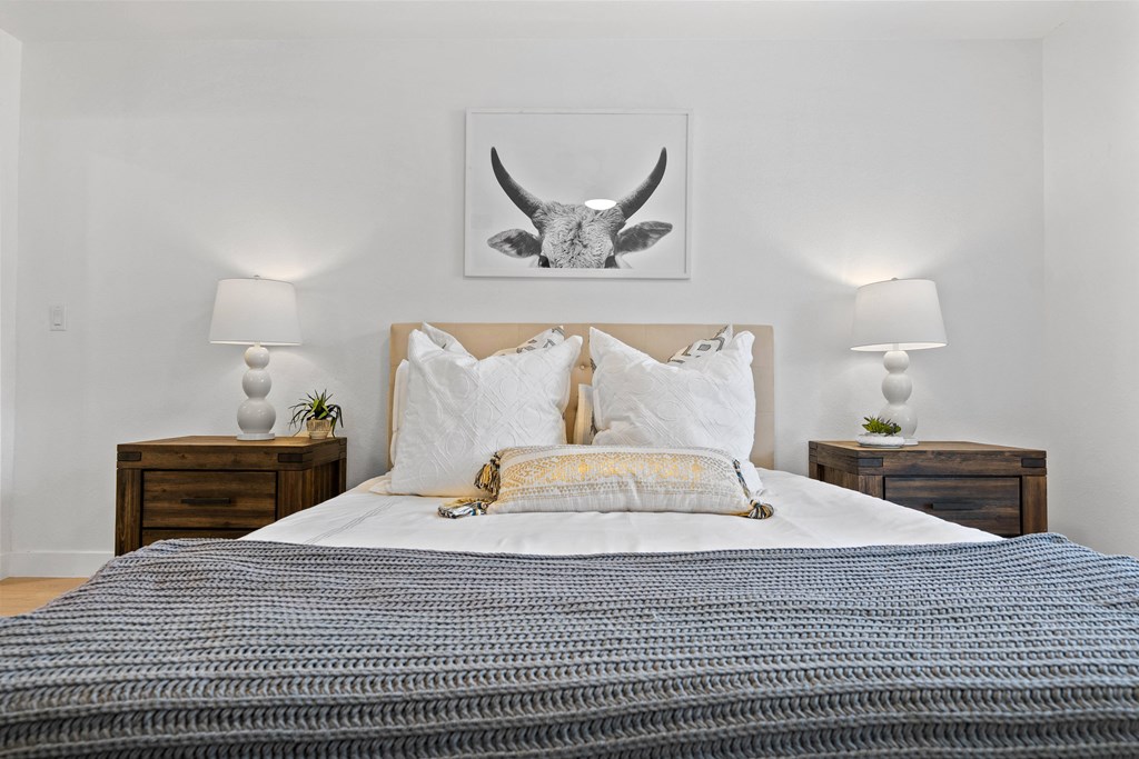 a bedroom with a bed and a picture of a bull