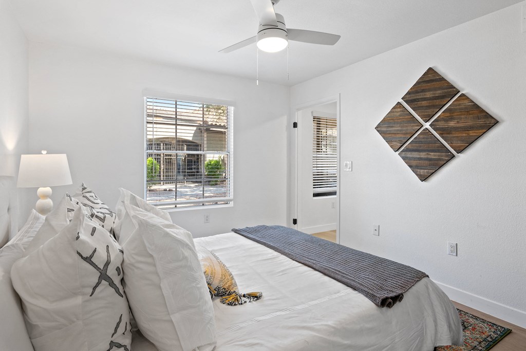 a bedroom with a large bed and a ceiling fan
