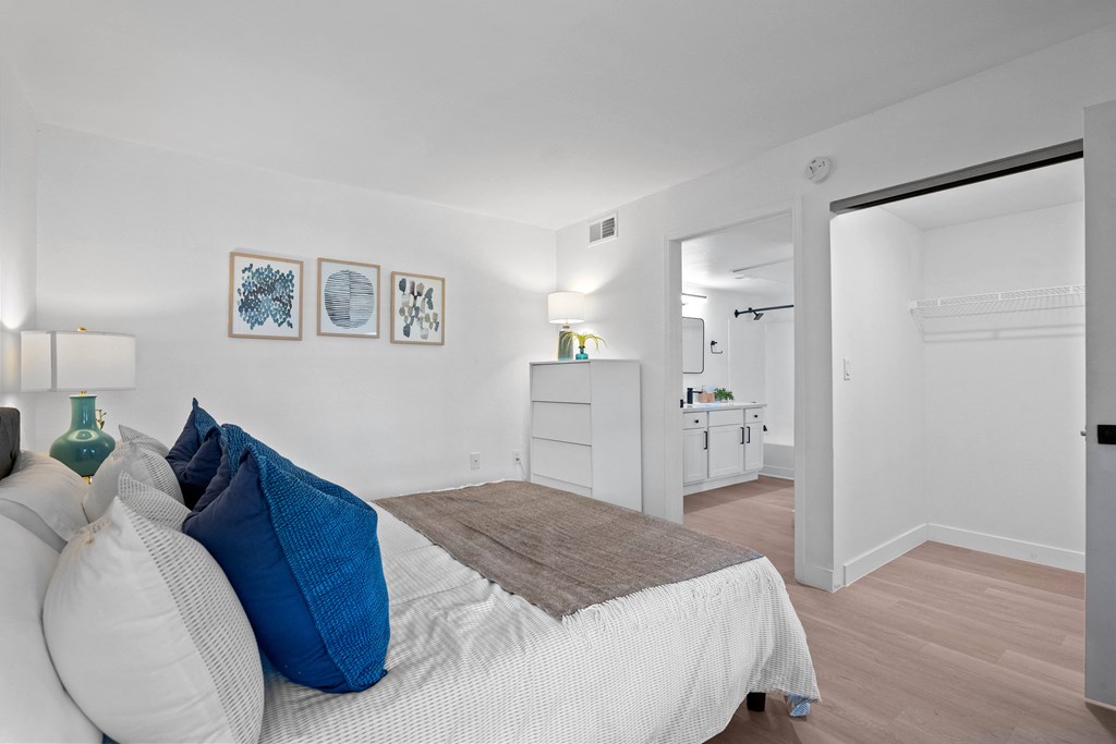 a bedroom with a bed and a closet and a bathroom