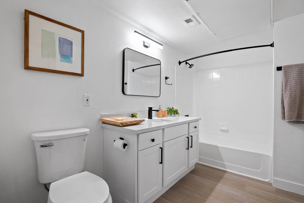 a white bathroom with a white toilet and a white sink