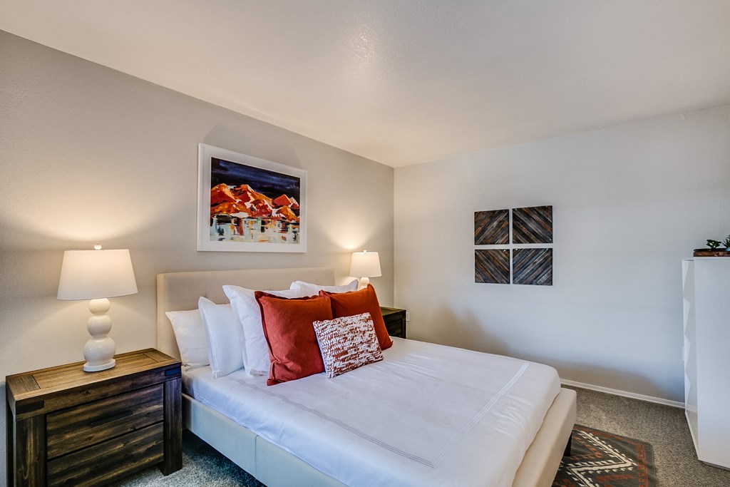 a bedroom with a large white bed and two night stands with lamps