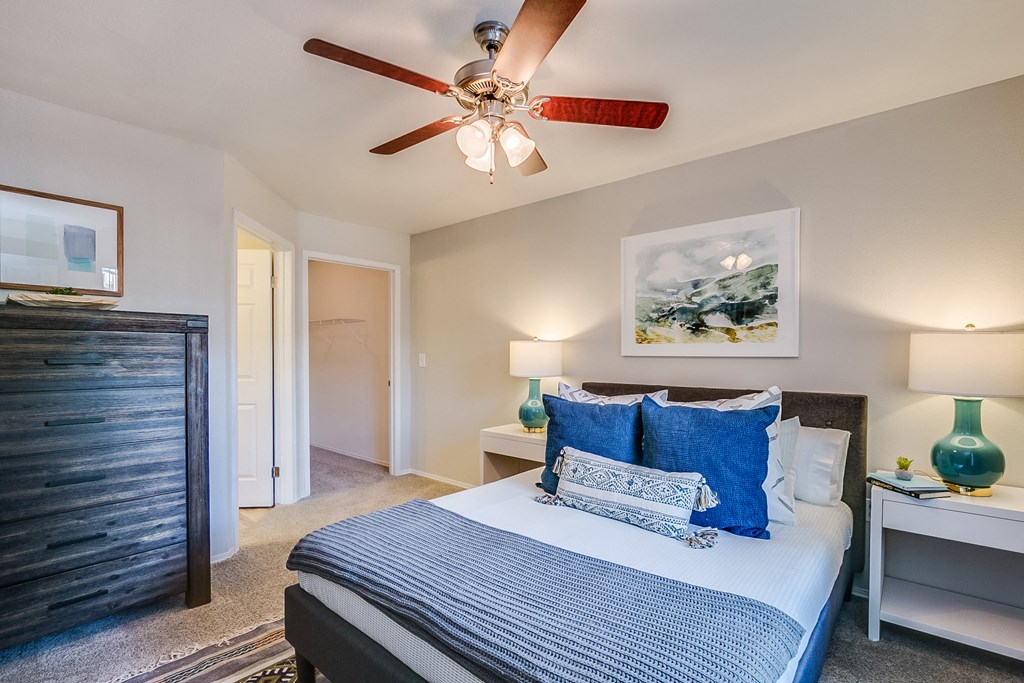 a bedroom with a large bed and a ceiling fan